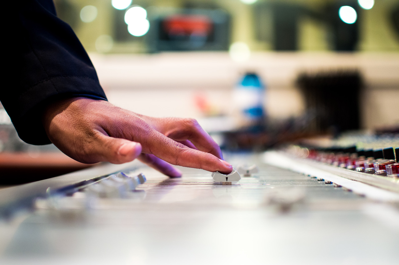 Hand adjusting a mixing console